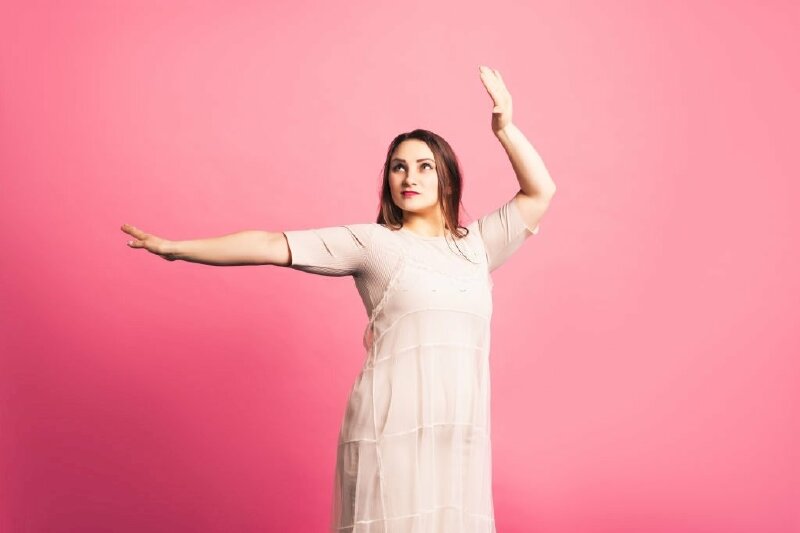 Kiểu chụp ảnh dành cho các cô nàng mủm mỉm với dáng đứng thẳng tự nhiên, một tay dang ngang, một tay dơ cao tạo dáng, người và mặt hơi nghiêng