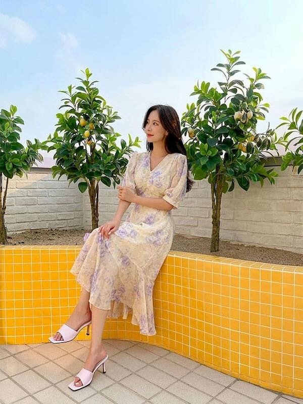 Cách tạo dáng chụp ảnh váy dài mắt nhìn nghiêng, tay chạm tay, tay còn lại co nhẹ đặt lên đùi, chân bắt chéo