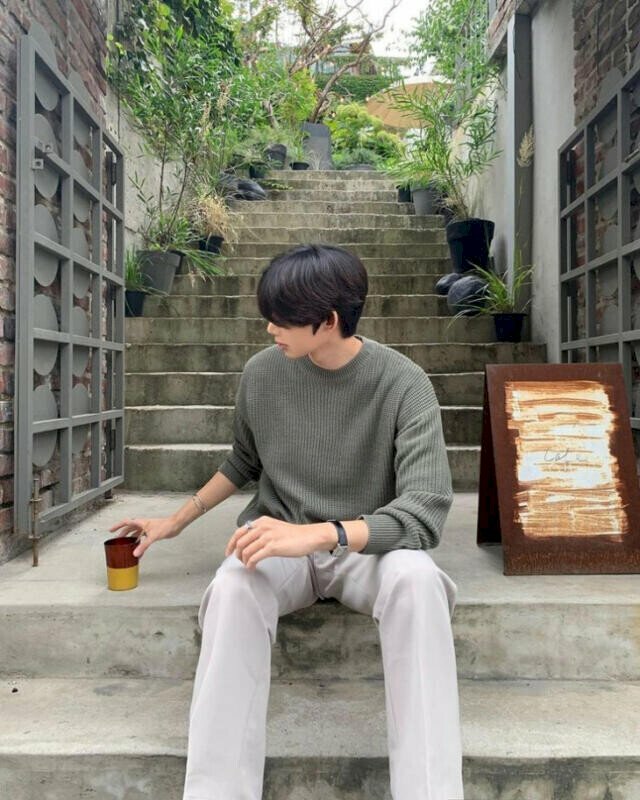 Cách tạo dáng nam ngồi trên bạc thang cùng cốc cafe sáng trong bộ quần áo thoải mái, 1 tay đặt lên đùi, 1 tay chạm nhẹ cốc cafe tạo vẻ đẹp trai có nhiều người theo