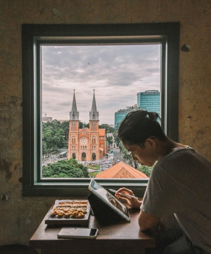 Kiểu tạo dáng nam đang ngồi bên khung cửa sổ quán cafe đang suy tư với chiếc ipad, 1 tay cầm bút, tay còn lại chống lên bàn đầu hơi cúi