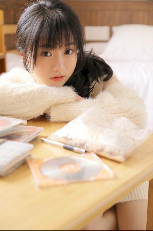 Các chụp ảnh dễ thương với dáng ngồi tay xếp để lên bàn, mặt tựa vào tay, mắt mở to nhìn ống kính