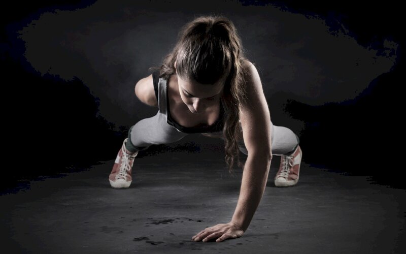 Tạo dáng nữ gymer đang hít đất bằng một tay chất ngầu, một tay để sau lưng