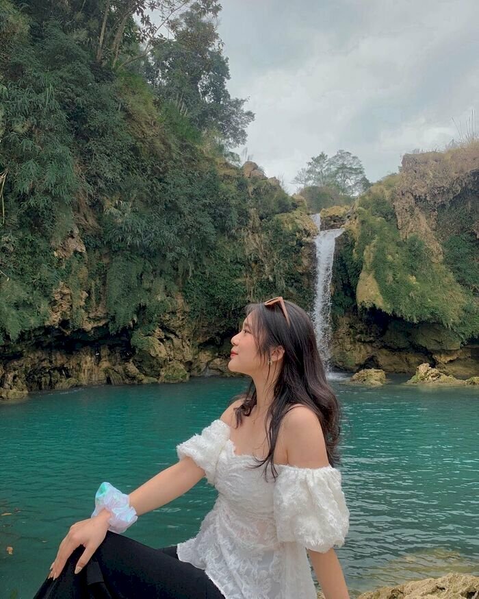 Cách tạo dáng chụp ảnh với thác nước cho nữ theo kiểu nàng thơ trong sáng, với kiểu này bạn hãy mặc áo màu trắng, ngồi nghiêng phía trước thác nước, để vai vuông góc với ống kính, hãy ngồi đặt 1 tay chống phía sau và 1 tay đặt lên gối, gương mặt hơi ngước lên. 