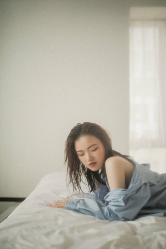 Cách tạo dáng chụp ảnh trong phòng ngủ theo phong cách dịu dàng, hãy nằm úp lên giường chống cánh tay xuống giường, hướng vai về phía ống kính, mặt cùng quay lại cùng hướng với vai để có được bức hình đẹp.