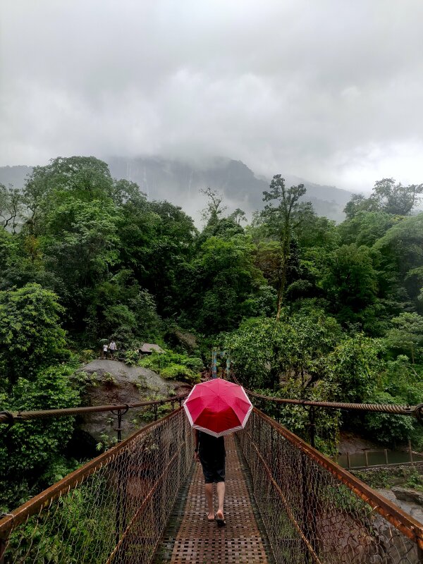 Tạo dáng đẹp như một thục nữ với chiếc dù đỏ của cô gái đang bước đi tự nhiên trên cầu