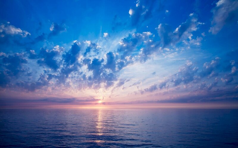 Hình ảnh bầu bình minh ửng hồng trên bãi biển và bầu trời xanh ngát