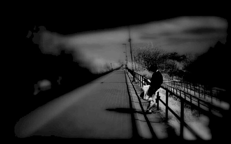 Hình ảnh cô gái đứng một mình tựa vào hàng rào cúi mặt buồn bã