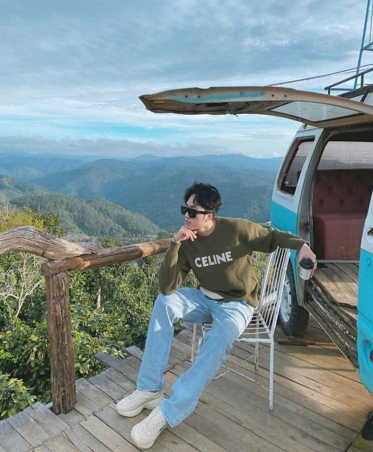 Kiểu dáng người trong chiếc áo Celine vào quần Jean xanh, một tay cầm cốc cafe, tay còn lại chống càm, người hướng một bên mắt đắm nhìm vào khung cảnh cao nguyên bát ngát