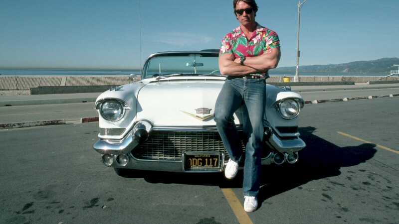 Kiểu tạo dáng nam thần đứng trước mui xe ô tô một chân co nhẹ, đứng khoanh tay, mắt nhìn ống kính