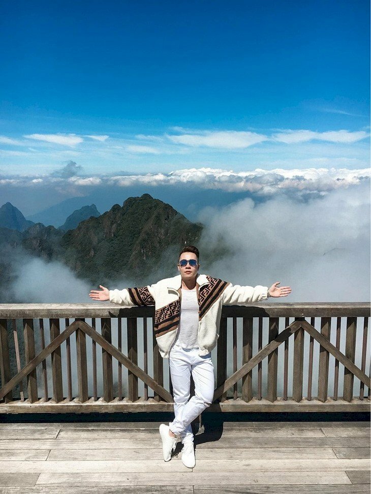 Kiểu tạo dáng nam thần thái cực chill đang đứng giữa cao nguyên rừng núi bạt ngàn mây trắng dáng người dang hai tay mặt hướng lên trời, người đứng thẳng, chụp góc từ trên xuống