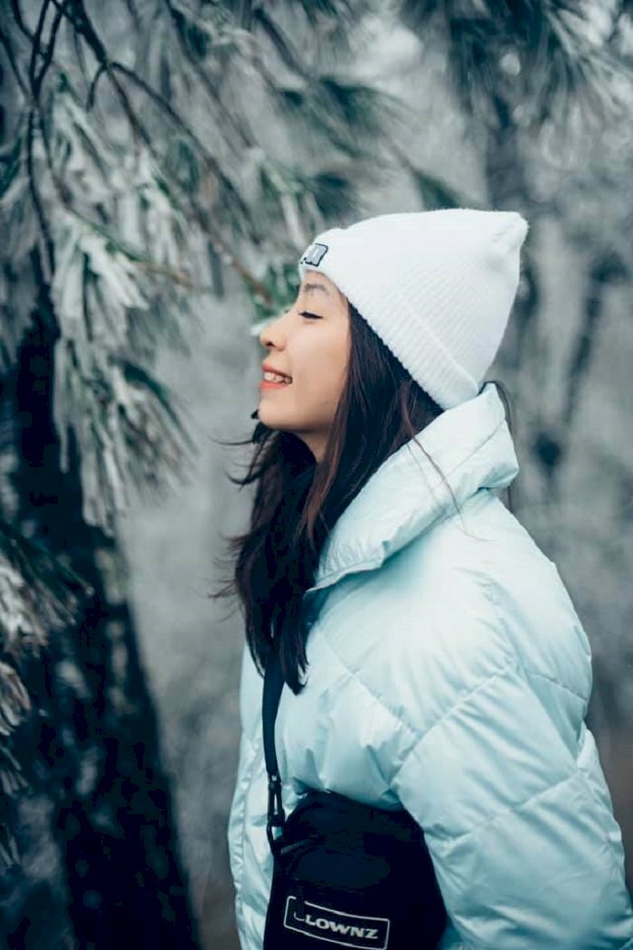 Tạo dáng cực chill dưới trời mùa Đông ở Sapa của cô gái trong bộ áo áo màu trắng với đôi mắt nhắm và miệng cười tươi