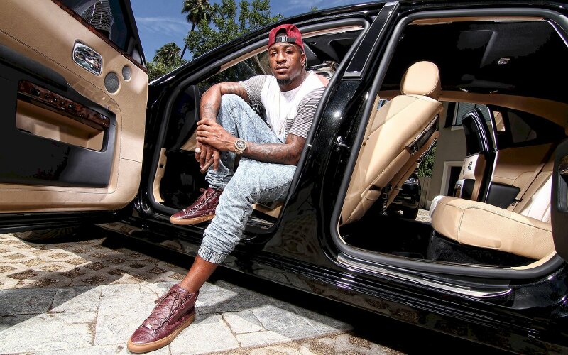 Tạo dáng nam thanh niên ngồi ô tô hướng người ta ngoài, một chân gác lên 2 tay nắm vào nhau cùng điếu cigar sang trọng và phong cách đội mũ lưỡi trai ngược rất cá tính