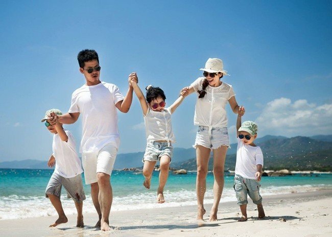 Cách tạo dáng chụp ảnh gia đình 5 người ở biển đẹp, cả nhà cùng đi dạo trên biển, bố mẹ nắm tay con đi dạo vui vẻ. 