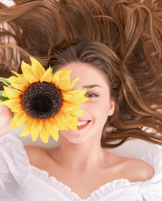 Cách tạo dáng với hoa hướng dương che mặt với kiểu này, hãy nằm xuống, để tóc xõa xung quanh đầu, tay cầm bông hoa lên che 1 bên mặt, gương mặt cười tươi, với góc chụp chính diện từ trên xuống bạn sẽ có được bức ảnh với bông hoa hướng dương đẹp nhất.