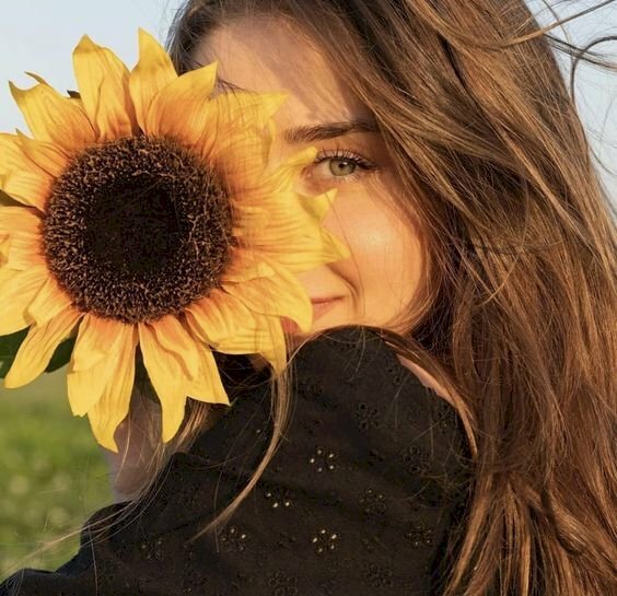 Cách tạo dáng với hoa hướng dương che mặt với góc chụp chính diện mặt, bờ vai quay thẳng vào ống kính, đầu nghiêng về phía vai, tay cầm bông hoa lên che 1 bên mặt, khuôn mặt cười mỉm, sẽ giúp bạn có được bức ảnh đẹp. 