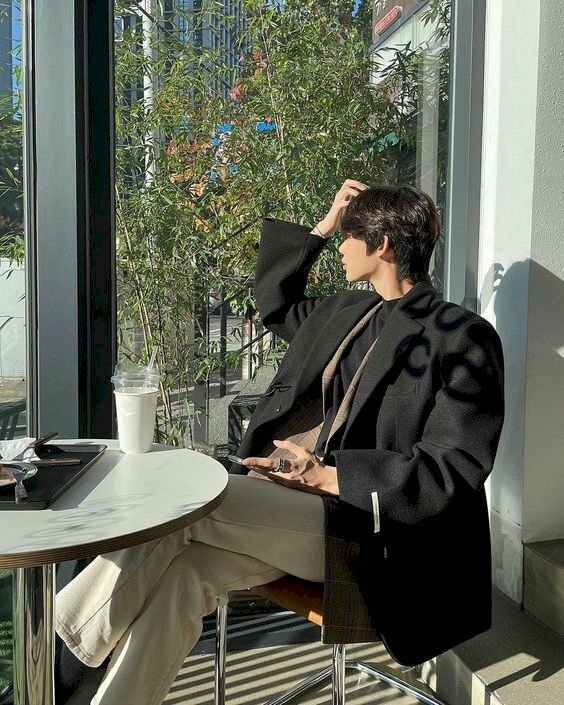 Tạo dáng chụp ảnh góc nghiêng nam cho nam ngồi trong quán cà phê, ngồi bắt chéo chân nhẹ, một tay để lên đùi, một tay đưa lên vuốt tóc, đầu quay nghiêng để tạo được đường lượn xương hàm đậm chất đàn ông.