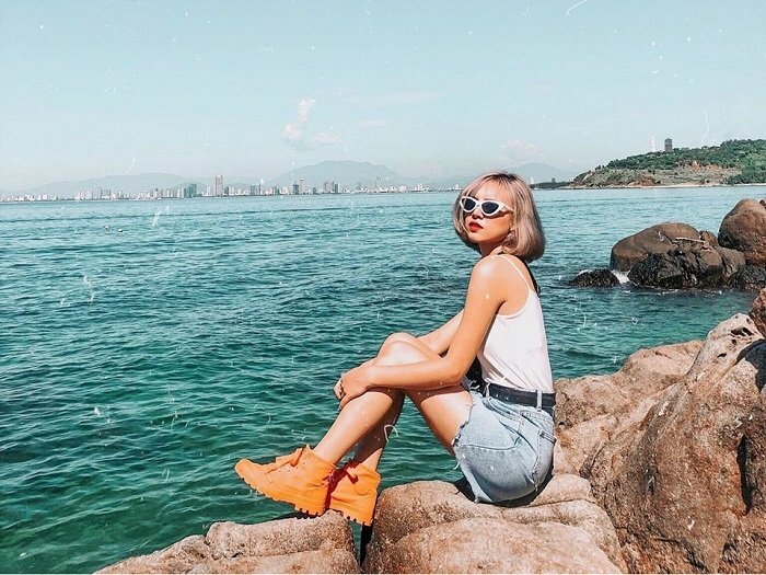 Cách tạo dáng chụp ảnh đẹp khi ngồi trên những tảng đá đang nằm xếp xen kẽ vào nhau tạo nên những góc nhìn vừa lạ vừa đẹp đá ở Bãi Đá Đen. Với kiểu chụp ảnh này bạn hãy ngồi lên tảng đá, ngồi thẳng lưng, hai chân hơi co lại, đưa tay vòng qua ôm đầu gối và quay lại nhìn vào ống kính để có được tấm ảnh đẹp.