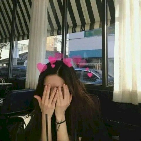 Cách selfie đẹp cho người không ăn ảnh bằng cách đưa 2 tay lên che mặt để chừa phần trán lại, kết hợp với những icon trái tim trên đầu sẽ có được bức ảnh cute đáng yêu.