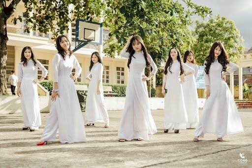 Cách tạo dáng chụp ảnh áo dài tập thể kiểu lầy lội dành cho nhóm học sinh 7 người, mặc áo dài trắng, mọi người xếp thành 3 hàng ngang và đứng kiểu dích dắc để không bị che khuất người đằng sau, mọi người cùng đưa 1 tay lên chống nạnh, 1 tay thả xuống, và đưa 1 chân ra.