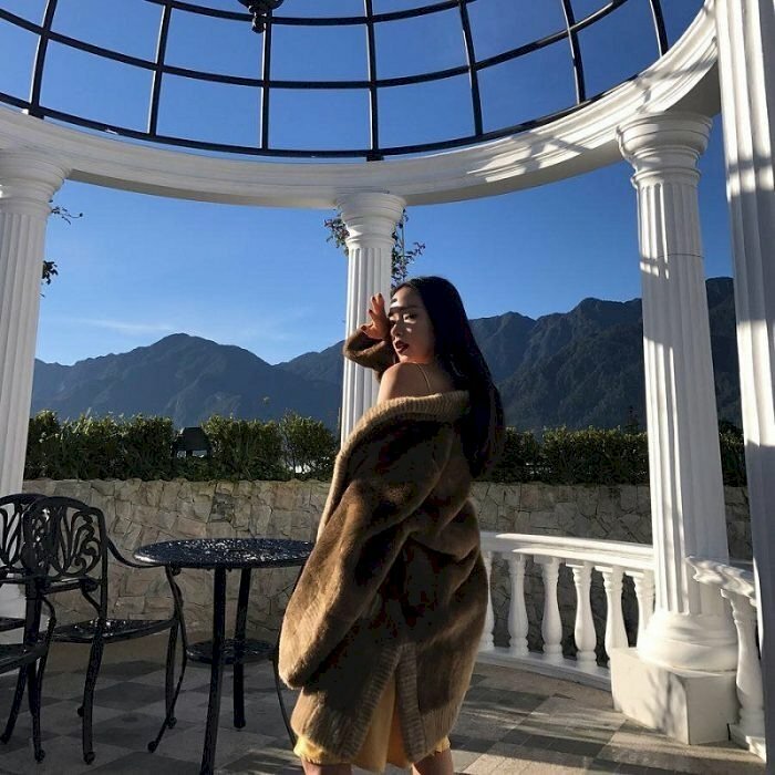 Tạo dáng bước đi quay lưng với mặt quay về hướng ống kính, một tay buông thẳng tự nhiên, một tay đưa lên che nhẹ nhàng, ánh mắt bờ môi biểu cảm kiêu kỳ