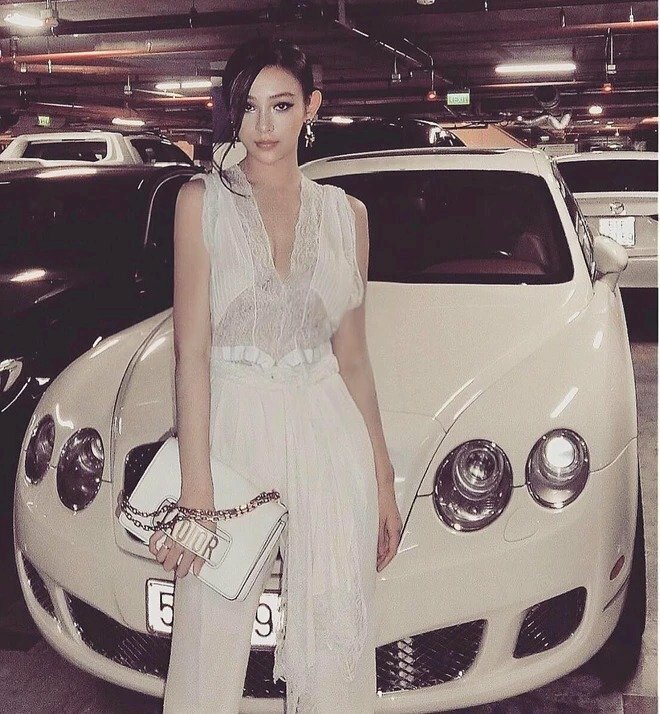 Tạo dáng đứng thẳng tựa vào xe, hai tay buông tự nhiên, mắt nhìn thẳng ống kính