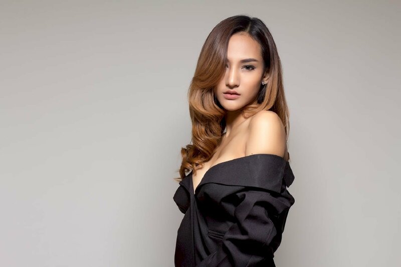 Tạo dáng tư thế đứng nghiêng, một vai hếch nhẹ lên trên,  mặt quay nghiêng nhìn thẳng vào ống kính, tóc xoã với một phần tóc mái che một phần gương mặt