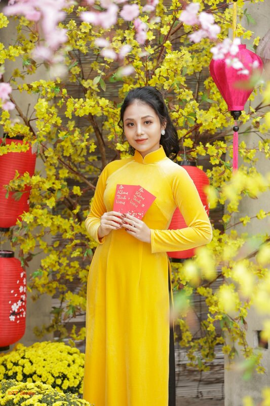 Tạo dáng đứng chụp ảnh áo dài tết thật dễ thương với những chiếc bao lì xì được cầm trên tay