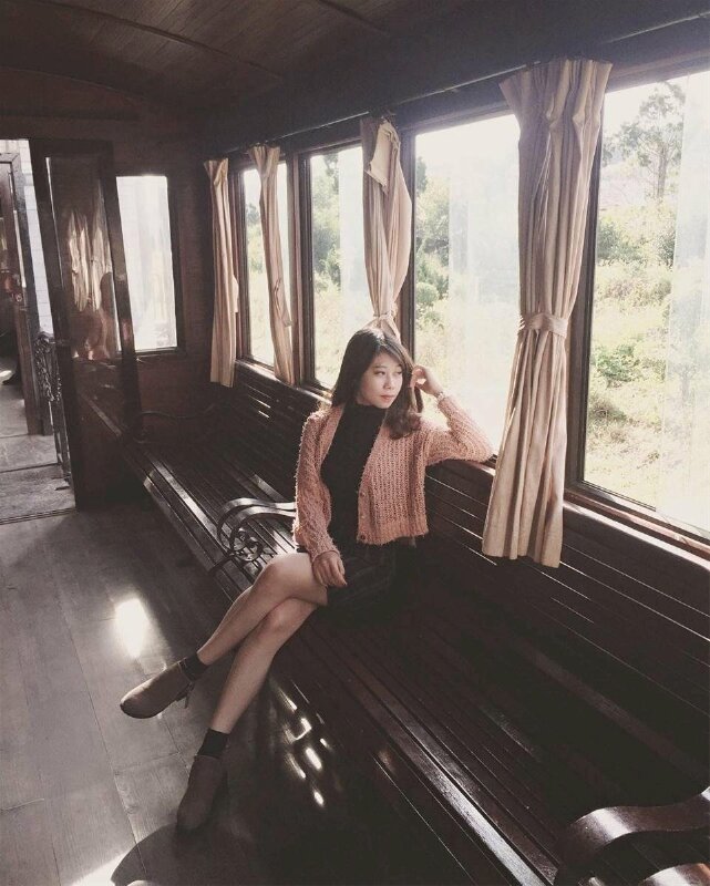  Mẫu tạo dáng ngồi nghiêng khi mặc váy ngắn, chân bắt chéo, mắt nhìn xa cùng không gian hoài niệm