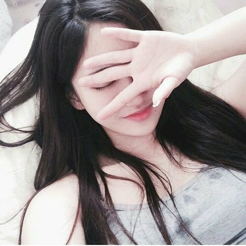 Tạo dáng đang nằm và xòe lòng bàn tay trắng trẻo của mình ra, đặt nhẹ nhàng lên gương mặt