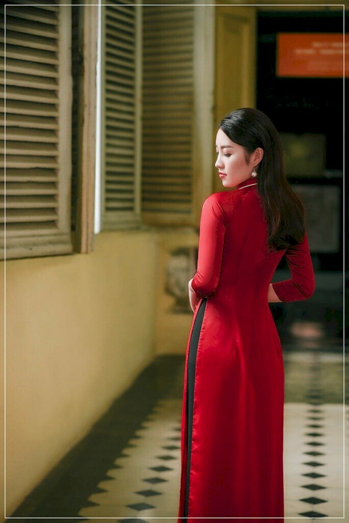 Tạo dáng áo dài chụp ảnh đứng quay lưng, mặt hướng về phía ống kính, mắt nhìn xuống, hai tay nhẹ nhàng đặt phía trước, tóc dài xoã tự nhiên