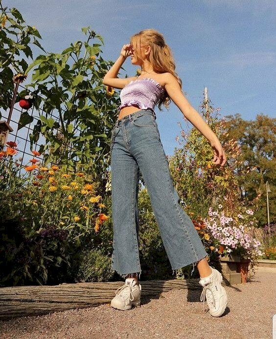 Tạo dáng chân đứng chữ A, đầu hướng quay nghiêng nhìn về phía trước, một tay nhẹ đưa lên như che nắng, một tay dang rộng tự nhiên