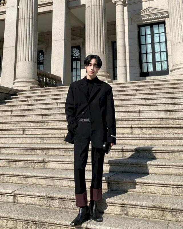 Tạo dáng đứng thật tự nhiên với một chân thẳng và một chân khuỵu gối nhẹ, một tay đút túi quần,