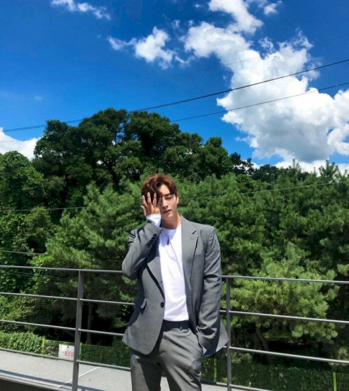 Tạo dáng đơn giản một tay hơi che mặt, một tay đút túi quần