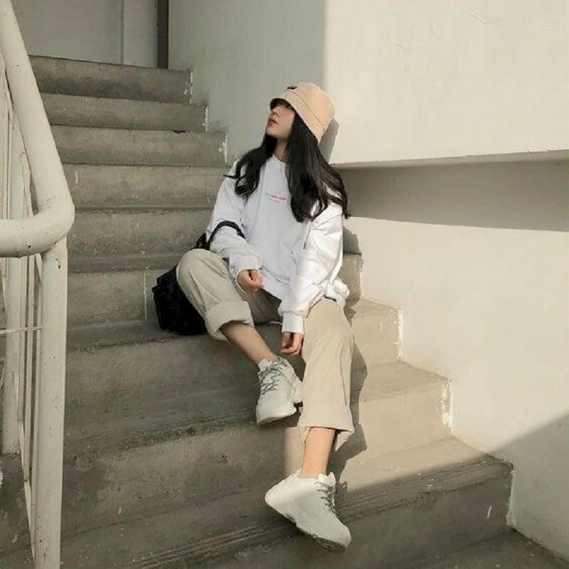 Mẫu tạo dáng chụp ảnh ngồi cầu thang, mặt hướng nhìn lên, trang phục khoẻ khoắn