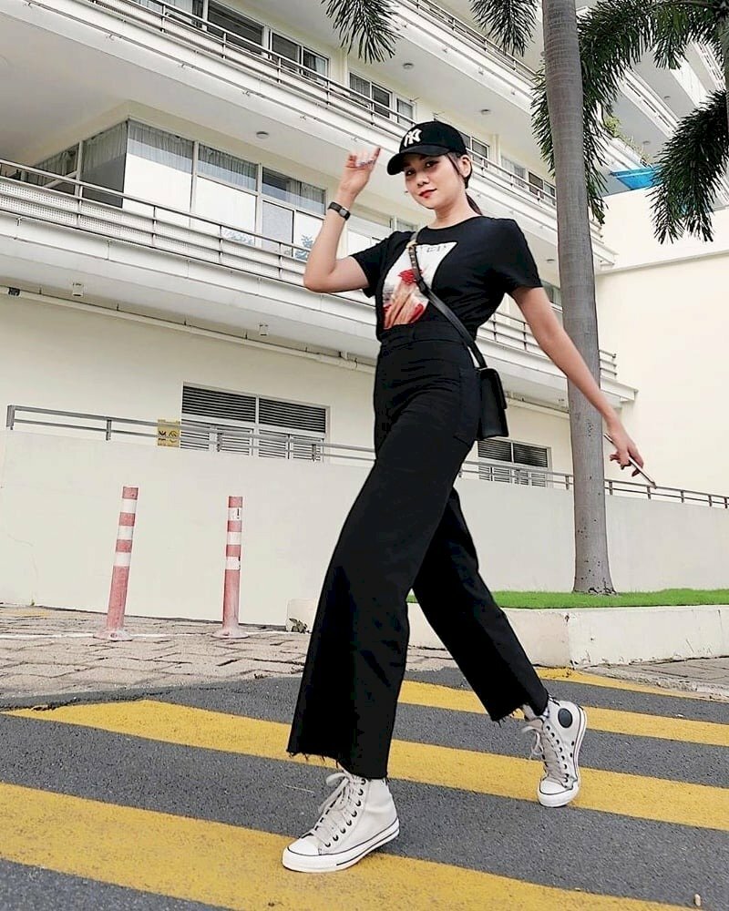 Tạo dáng bước đi khoan thai, một tay đưa ra sau, một tay đưa lên như vịnh vào nón