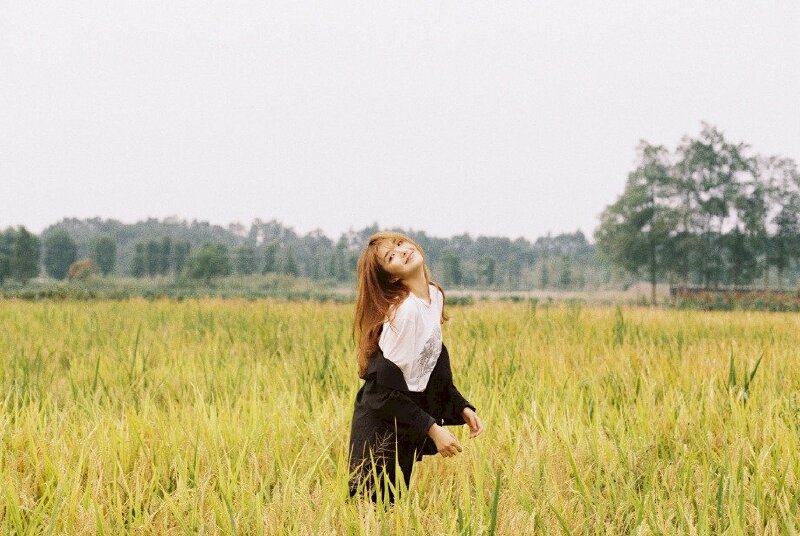 Tạo dáng như đang chạy tung tăng chợt dừng lại quy nghiêng người, nghiêng đầu và cười duyên nhìn vào máy ảnh, áo khoác hơi trễ vai