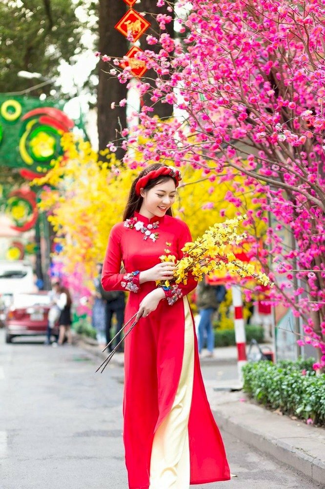 Tạo dáng bước đi thật tự nhiên, uyển chuyển, tà áo dài tung bay phấp phới trong gió, tay có thể ôm một cành hoa