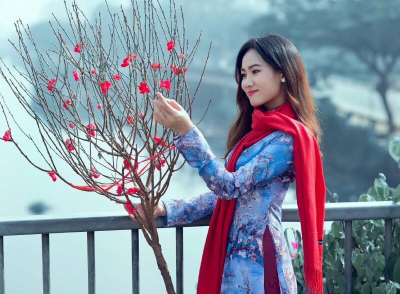 Tạo dáng bước đi tự nhiên trên phố trong tà áo dài và một chiếc khăn choàng cổ duyên dáng làm phụ kiện