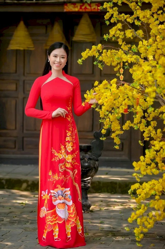 Tạo dáng đứng thật tự nhiên, thả lỏng cơ thể, một tay để trước ngực, một tay vịnh cành hoa