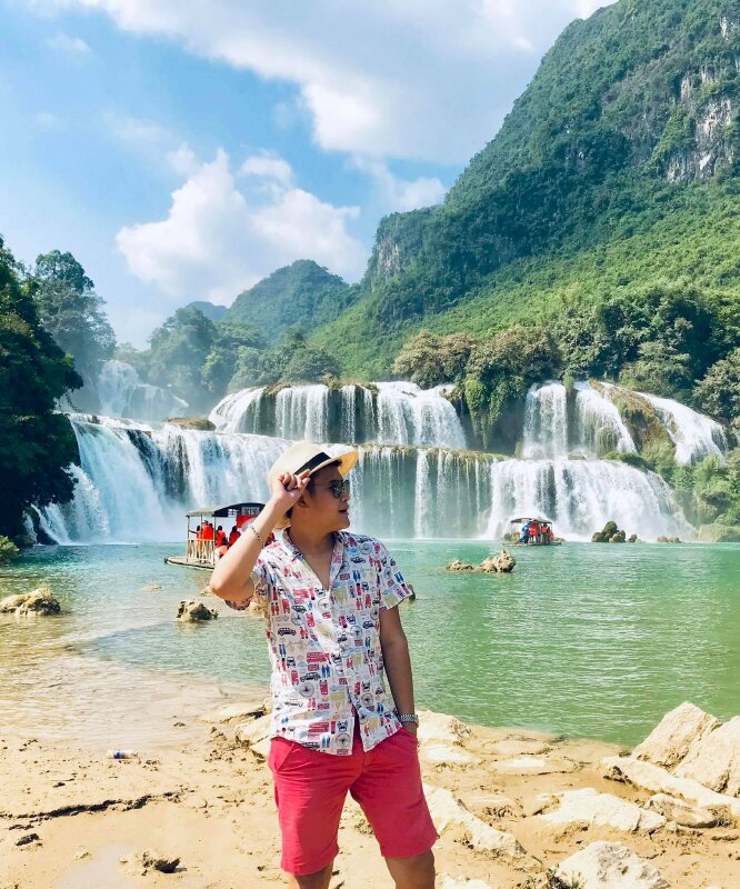 Cách tạo dáng đứng đơn giản hướng về ống kính, mặt quay nghiêng, một tay đút túi quần, một tay vịnh nhẹ vành nón