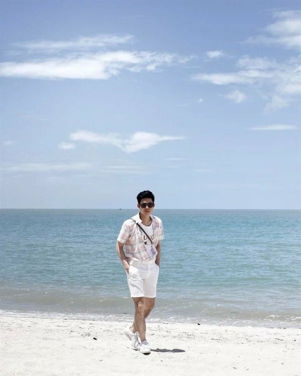 tạo dáng chụp ảnh dạo biển cho nam outfit trẻ trung, năng động, với phong cách như bị chụp lén