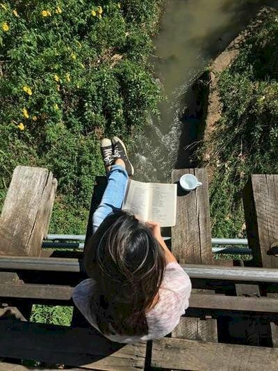 Tạo dáng ngồi vắt vẻo ở đâu đó đọc sách, với góc chụp từ trên xuống