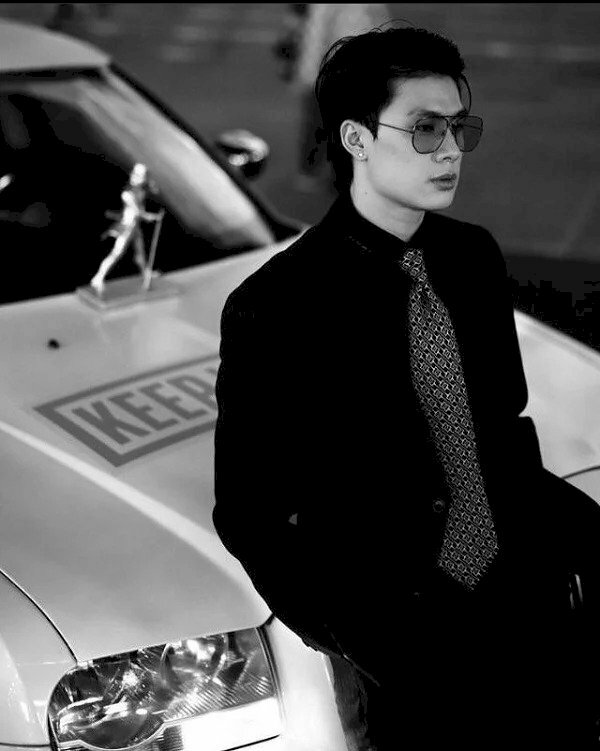  Tạo dáng chụp ảnh dựa lưng vào xe hơi với mắt nhìn đầy suy tư