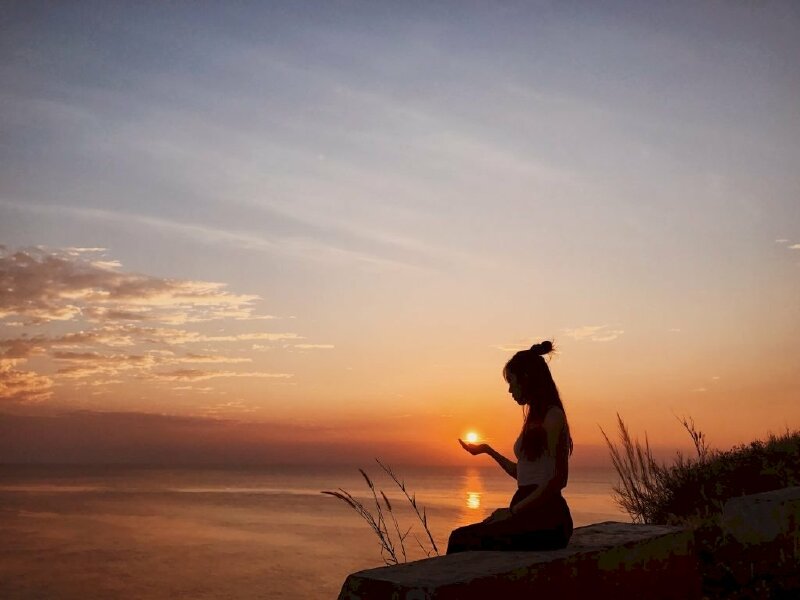 Dáng ngồi tự nhiên thật dịu dàng với một tay đưa ra như muốn bắt lấy mặt trời, chụp ảnh góc nghiêng ngược sáng