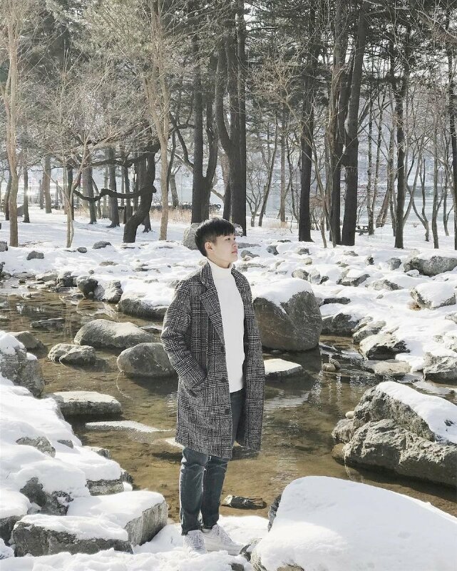 Tạo dáng đứng nghiêng với hai tay đút túi áo, mặt hướng nhìn thẳng