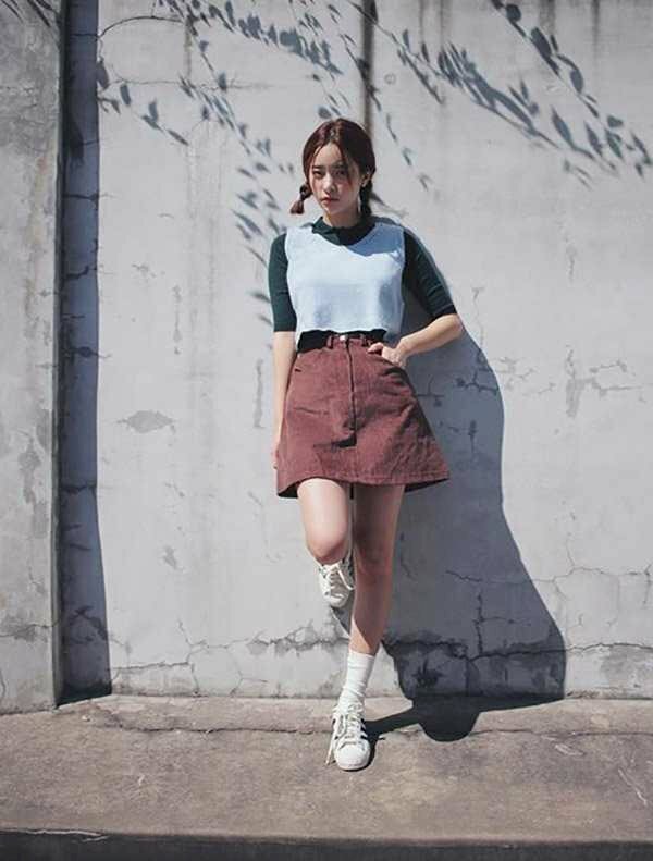 Mẫu tạo dáng chụp ảnh ngầu cute dựa lưng vào tường, một chân co nhẹ, một tay nhét vào túi váy hay quần