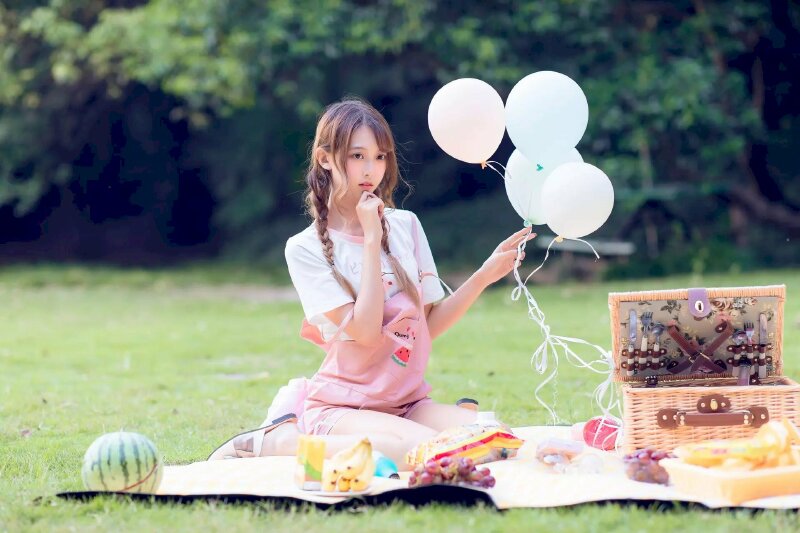 Tạo dáng ngồi với hai chân xếp về sau, tay đưa lên cằm, một tay cầm hoa hoặc bóng bay, mắt nhìn ngây thơ