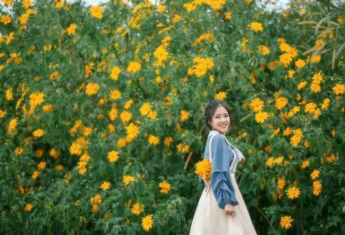 Tạo dáng quay lưng nhưng mặt hướng về phía ống kính nở một nụ cười dễ thương