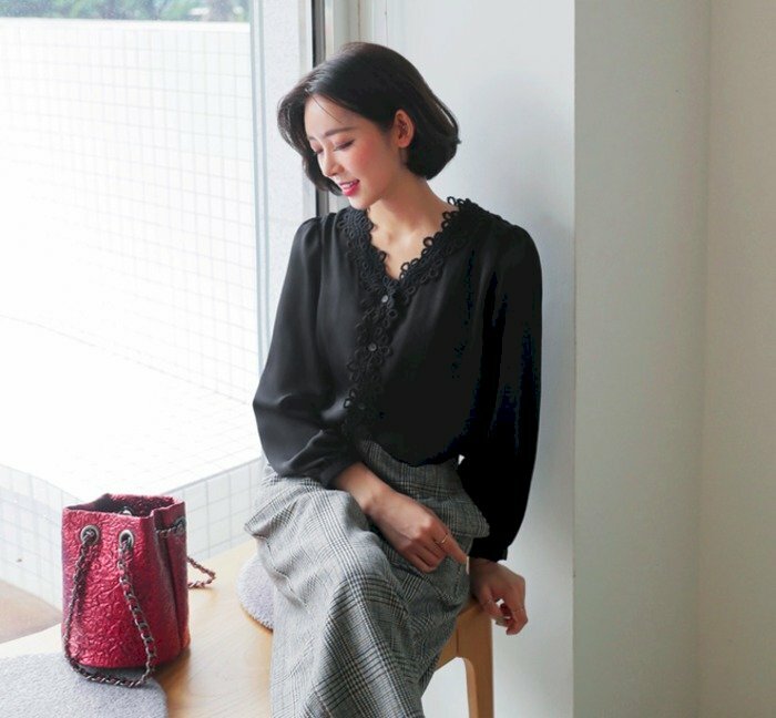 Một chiếc túi xinh đặt bên cạnh, tạo dáng ngồi tự nhiên cúi nhẹ khuôn mặt