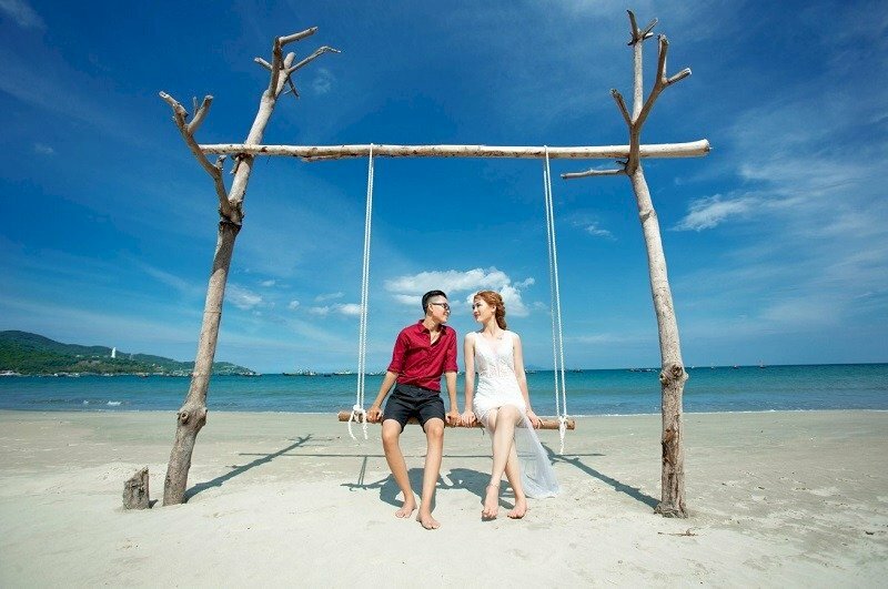 Tạo dáng chàng trai và cô gái  ngồi trên xích đu, đung đưa nhẹ nhàng, quay mặt nhìn nhau cười 